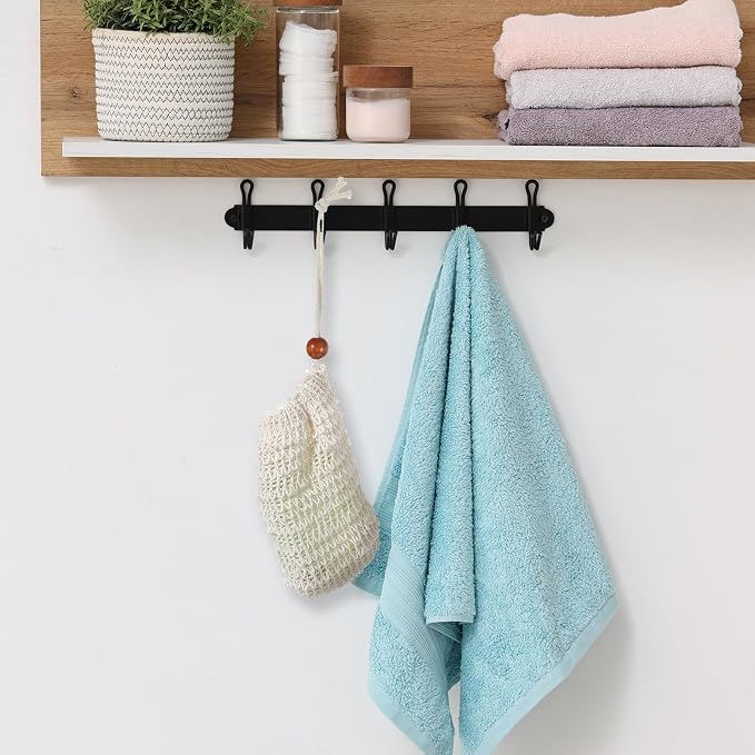 Natural sisal soap saver bag with wooden bead hanging to dry beside a blue towel